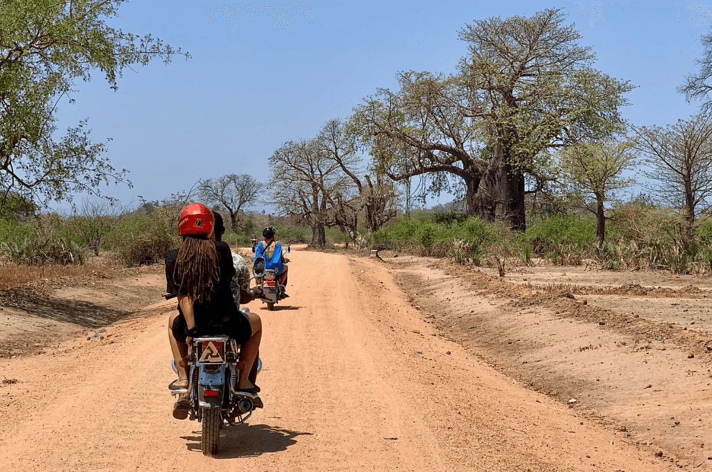 Toeristen achterop een motor taxi op een zandweg in Malawi